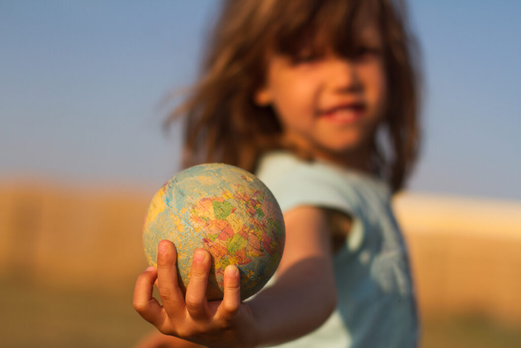 Child hand holding an earth toy globe