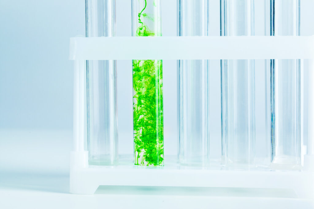 Green liquids in test tubes in chemical laboratory close up